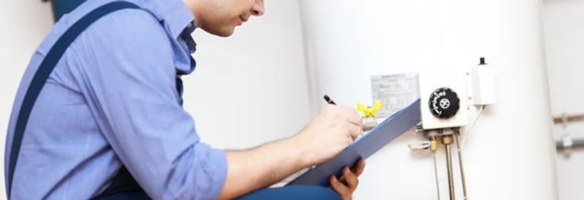 Water heater repair technician inspecting the unit and recording service notes in Oakland, CA